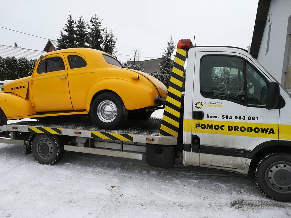Zabytkowy samochód transportowany przez pomoc drogową u Słowika